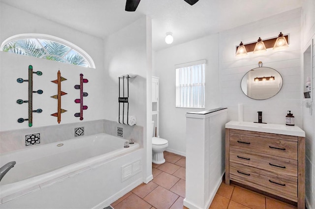 bathroom featuring toilet, vanity, tile patterned floors, and a bathtub