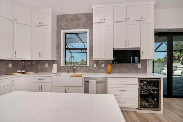 kitchen with light hardwood / wood-style flooring, white cabinets, beverage cooler, backsplash, and dishwasher