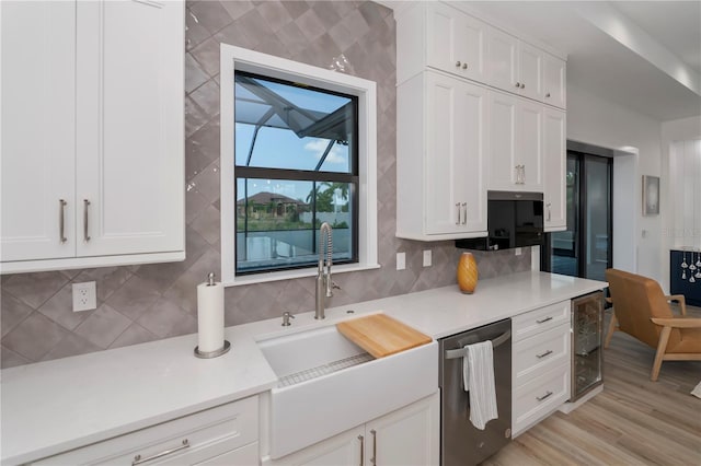 kitchen with light hardwood / wood-style floors, white cabinetry, stainless steel dishwasher, beverage cooler, and tasteful backsplash