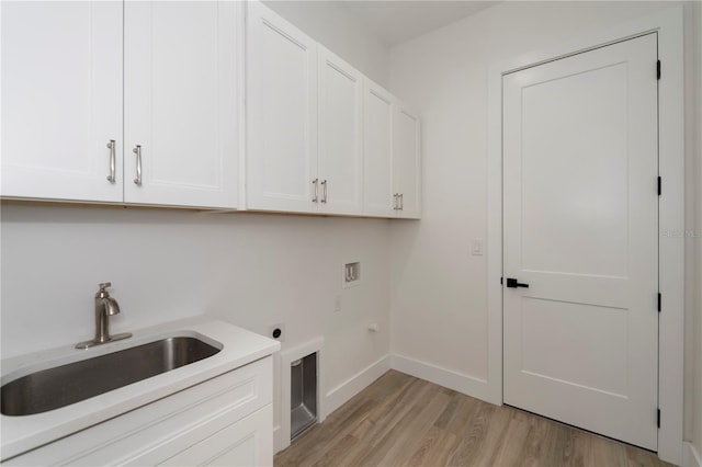 washroom with cabinets, electric dryer hookup, washer hookup, light wood-type flooring, and sink