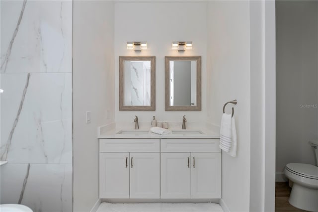 bathroom featuring hardwood / wood-style flooring, toilet, and dual bowl vanity