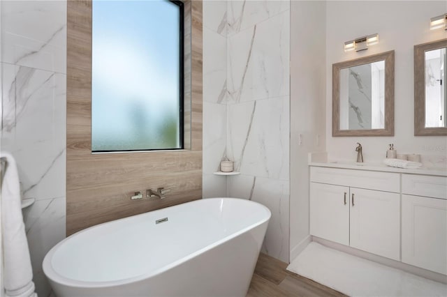 bathroom with tile walls, a bathtub, and oversized vanity