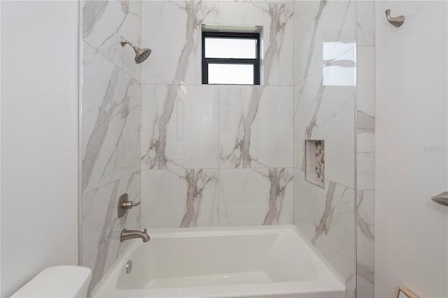 bathroom with toilet and tiled shower / bath combo