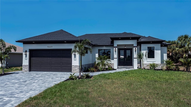 prairie-style house featuring a garage and a front yard