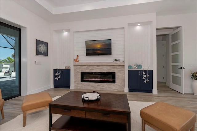 living room with built in shelves and light hardwood / wood-style floors