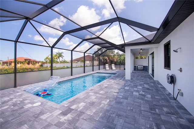 view of swimming pool with pool water feature, a lanai, a patio area, and ceiling fan