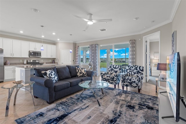 living room with ceiling fan, sink, light tile patterned floors, and crown molding