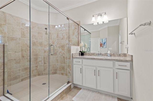 bathroom featuring tile patterned floors, a shower with door, crown molding, and vanity