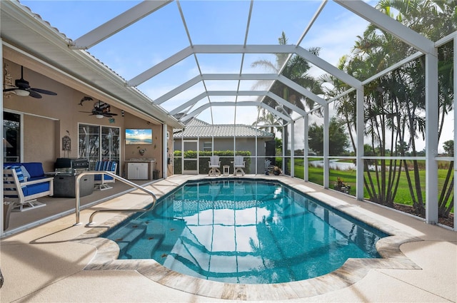 view of swimming pool with ceiling fan, a lanai, area for grilling, and a patio