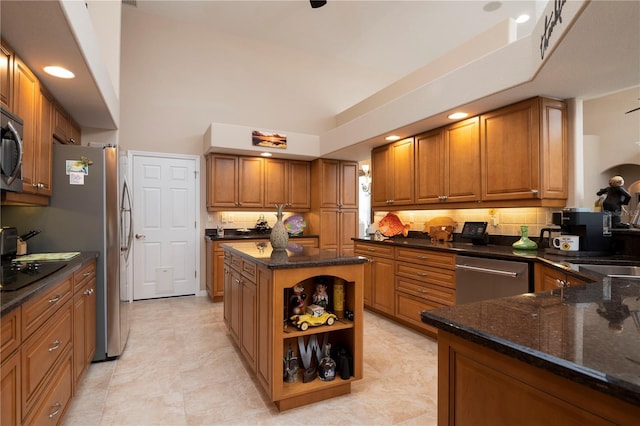 kitchen featuring appliances with stainless steel finishes, dark stone countertops, and decorative backsplash