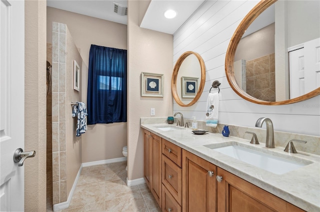 bathroom with toilet, vanity, tile patterned flooring, and wood walls