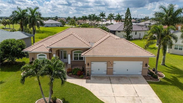 mediterranean / spanish house with concrete driveway, stucco siding, a tile roof, an attached garage, and a front yard