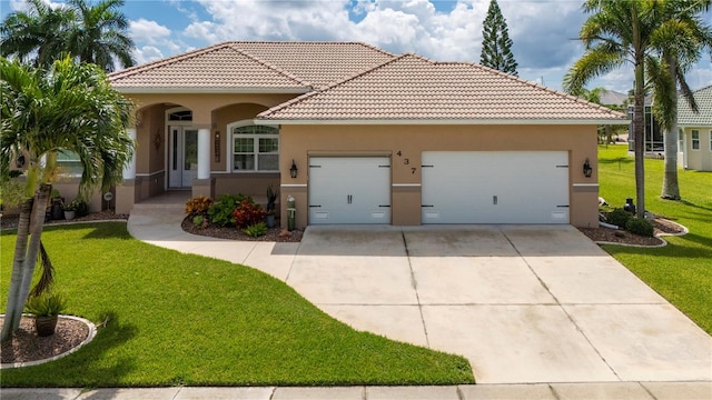 mediterranean / spanish home with stucco siding, driveway, a tile roof, a front yard, and a garage