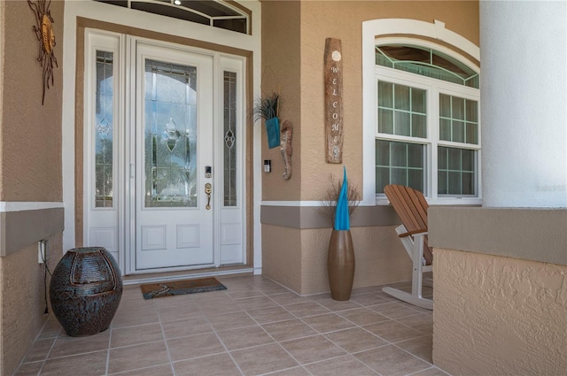 doorway to property with a porch and stucco siding