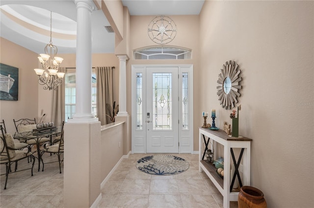 foyer featuring decorative columns, visible vents, a chandelier, and baseboards