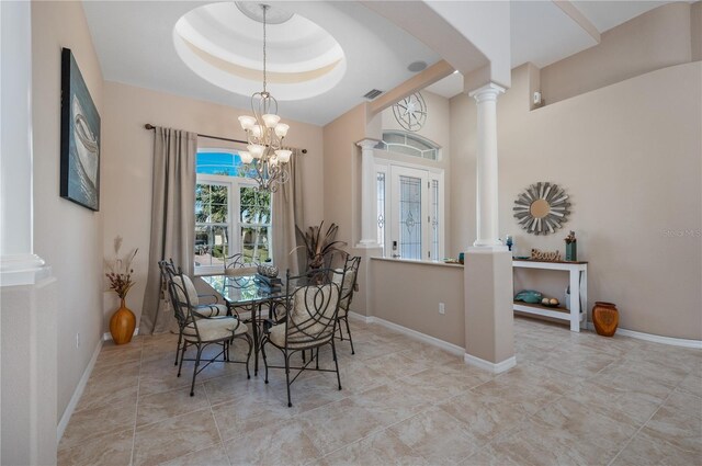 dining space with a notable chandelier, a raised ceiling, visible vents, ornate columns, and baseboards