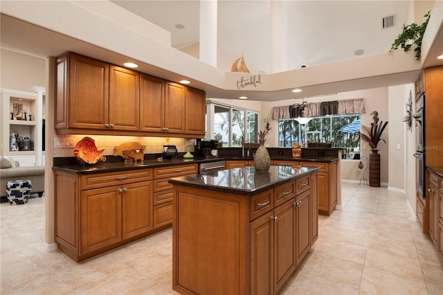 kitchen featuring brown cabinetry, a center island, visible vents, and a peninsula