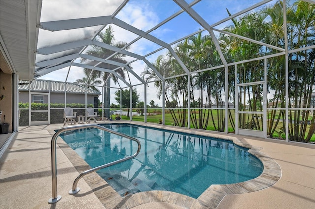 outdoor pool featuring glass enclosure and a patio area