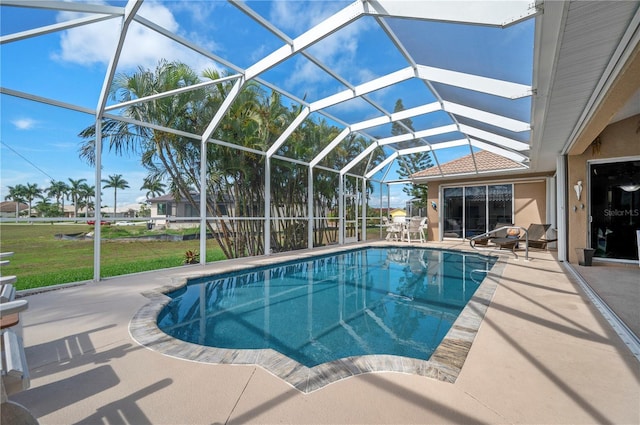 pool featuring a lanai, a patio area, and a yard