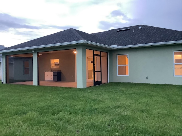 back of property featuring a lawn