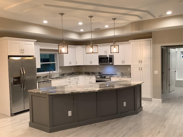 kitchen with a spacious island, sink, white cabinetry, appliances with stainless steel finishes, and pendant lighting