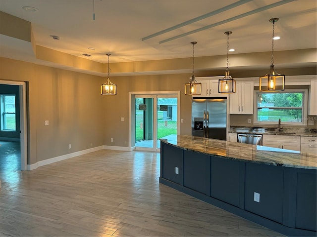 kitchen featuring pendant lighting, sink, white cabinets, dark stone counters, and stainless steel appliances