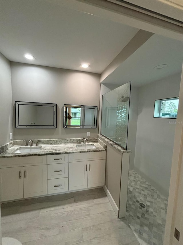 bathroom featuring a tile shower and vanity