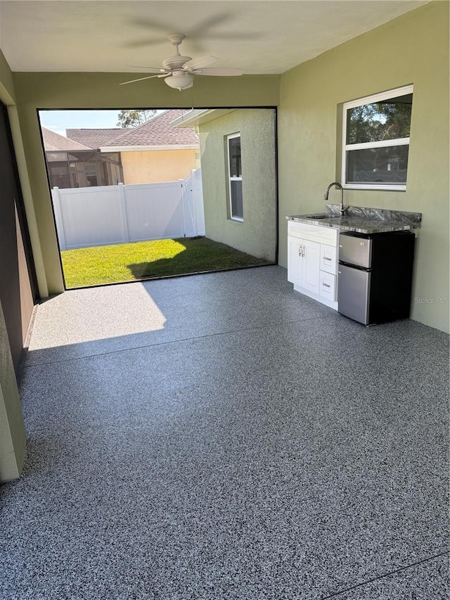 unfurnished sunroom with sink and ceiling fan