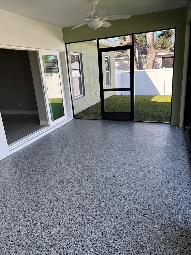 unfurnished sunroom featuring ceiling fan