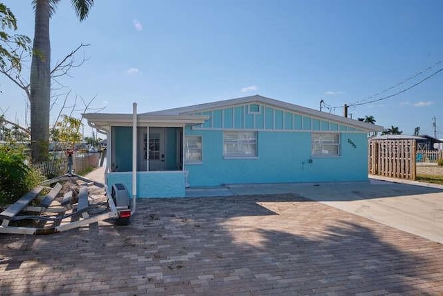 view of front of house featuring a sunroom and a patio