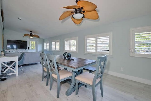 dining space with ceiling fan, a healthy amount of sunlight, lofted ceiling, and light hardwood / wood-style flooring