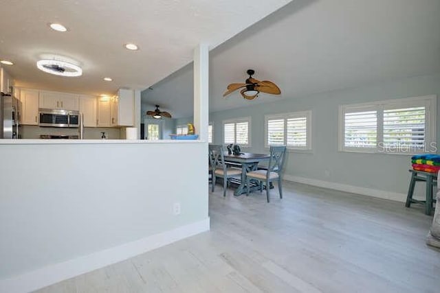 kitchen featuring ceiling fan, white cabinets, stainless steel appliances, and light hardwood / wood-style floors