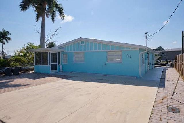 view of front of property featuring a sunroom and a patio area