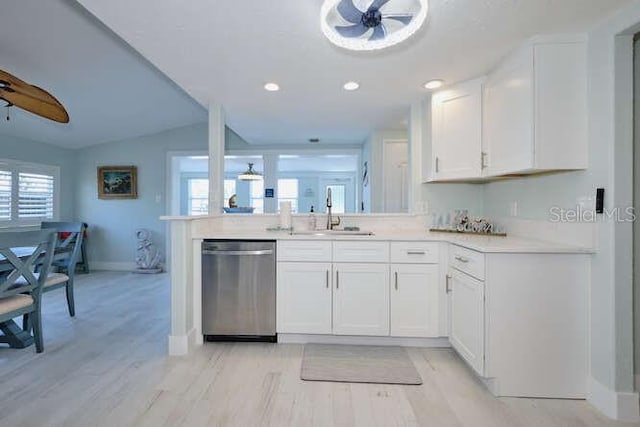 kitchen with white cabinetry, sink, stainless steel dishwasher, and light hardwood / wood-style flooring