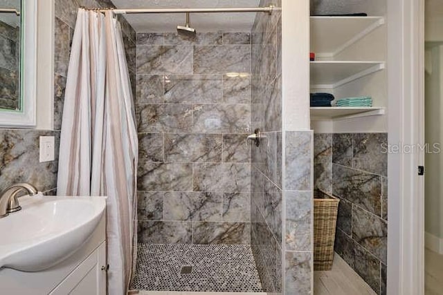 bathroom with vanity, curtained shower, and tile walls