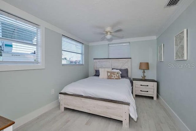 bedroom with ceiling fan, light hardwood / wood-style floors, and ornamental molding