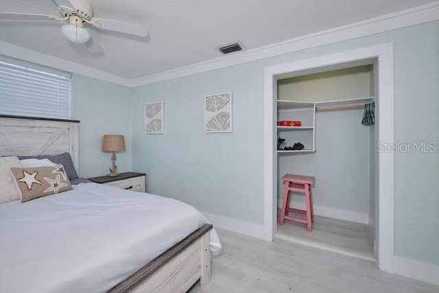 bedroom featuring crown molding, ceiling fan, a closet, and light hardwood / wood-style floors