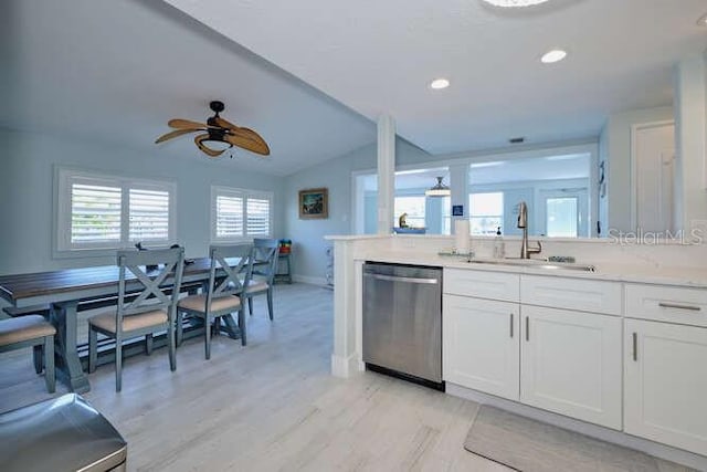 kitchen featuring light wood-type flooring, white cabinetry, stainless steel dishwasher, and sink