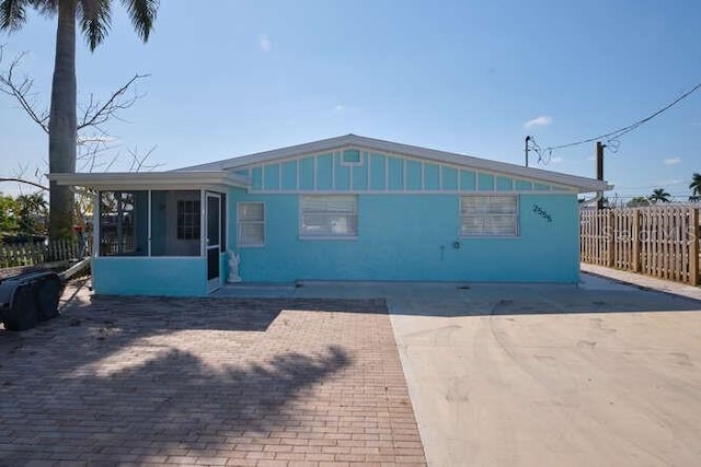 rear view of property featuring a patio area and a sunroom