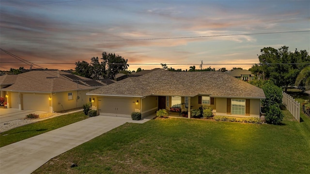 ranch-style home featuring a lawn and a garage