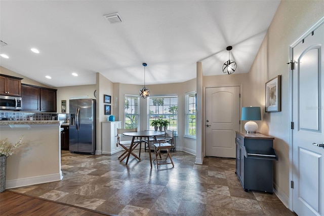 dining space featuring lofted ceiling and an inviting chandelier