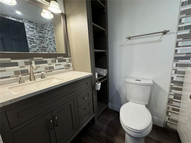 bathroom with tasteful backsplash, vanity, wood-type flooring, and toilet