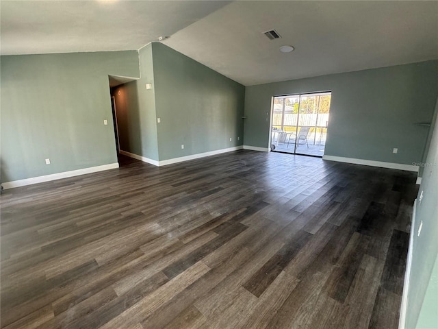 empty room featuring vaulted ceiling and dark wood-type flooring