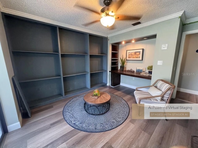 sitting room with hardwood / wood-style flooring, ornamental molding, ceiling fan, a textured ceiling, and built in shelves