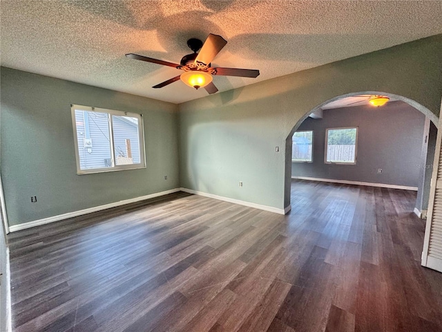 unfurnished room with ceiling fan, dark hardwood / wood-style floors, and a textured ceiling