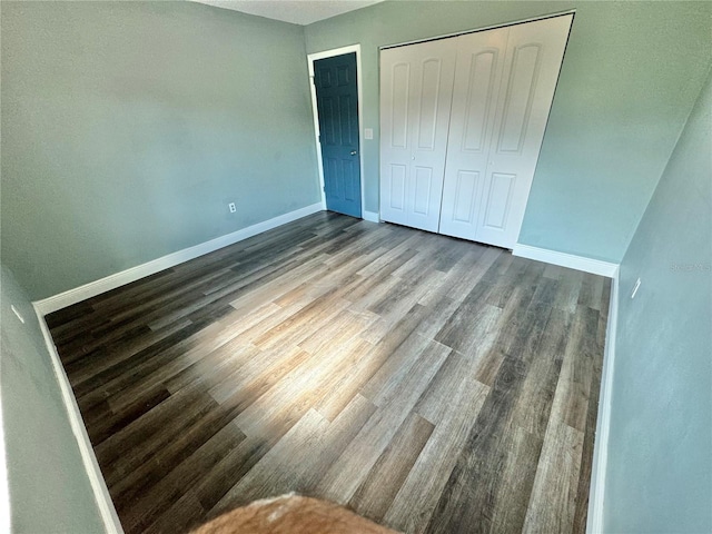 unfurnished bedroom with hardwood / wood-style flooring and a closet