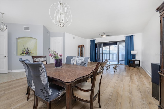 dining area with ceiling fan with notable chandelier and light wood-type flooring