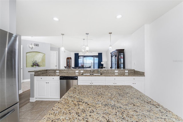 kitchen featuring white cabinetry, sink, light stone countertops, and appliances with stainless steel finishes