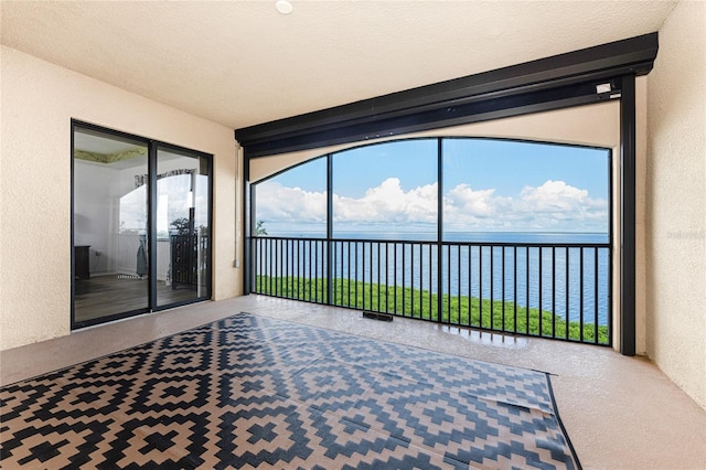 unfurnished sunroom with a water view