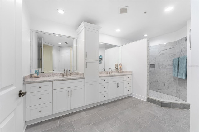 bathroom featuring vanity and tiled shower